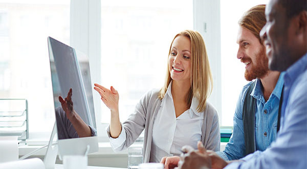 woman explaining a program in front of a computer