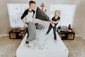 Kids_boy_girl_juming_on_bed_pillow_feathers
