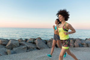 women_running_rocks_ocean_credit cards